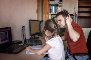 Padre enseñando a niña sobre la ciberseguridad para niños y el uso responsable del internet